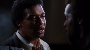 Movie still from “Sharky's Machine” (1981), directed by Burt Reynolds – A man talking to another man in front of a wall; Close Up shot, Over the shoulder angle