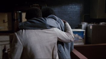 Movie still from “Sharky's Machine” (1981), directed by Burt Reynolds – Two men are hugging each other in a dark room; Close Up shot, Over the shoulder angle