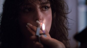 Movie still from “Sharky's Machine” (1981), directed by Burt Reynolds – A woman is lighting a cigarette with her hands; Close Up shot, Low angle