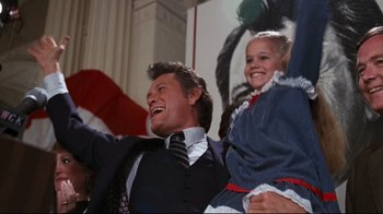 Movie still from “Sharky's Machine” (1981), directed by Burt Reynolds – A man and a little girl are smiling for the camera; Medium shot, Low angle