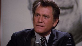 Movie still from “Sharky's Machine” (1981), directed by Burt Reynolds – A person wearing a suit and tie; Close Up shot, Low angle