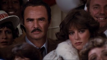 Movie still from “Sharky's Machine” (1981), directed by Burt Reynolds – A man and a woman standing next to each other; Close Up shot, Over the shoulder angle