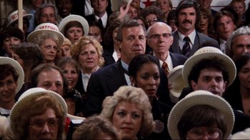 Movie still from “Sharky's Machine” (1981), directed by Burt Reynolds – A group of people in a room with hats on; Medium shot, High angle