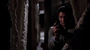 Movie still from “Sharky's Machine” (1981), directed by Burt Reynolds – A man in a suit holding a cell phone up to his ear; Close Up shot, Low angle