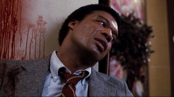 Movie still from “Sharky's Machine” (1981), directed by Burt Reynolds – A person wearing a suit and a tie; Close Up shot, High angle