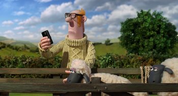 Movie still from “Shaun the Sheep Movie” (2015), directed by Mark Burton – A cartoon character is sitting on a park bench while holding a cell phone in one hand; Medium shot, Low angle