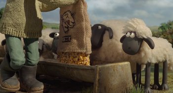 Movie still from “Shaun the Sheep Movie” (2015), directed by Mark Burton – A group of sheep eating food from a bag of corn; Wide shot, Low angle