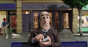 Movie still from “Shaun the Sheep Movie” (2015), directed by Mark Burton – A man sitting on top of a bench holding a cell phone; Close Up shot, Over the shoulder angle