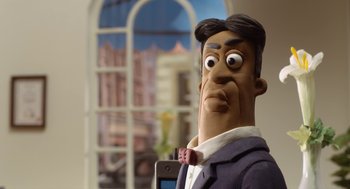 Movie still from “Shaun the Sheep Movie” (2015), directed by Mark Burton – A man's face with a cell phone in front of him; Close Up shot, Over the shoulder angle