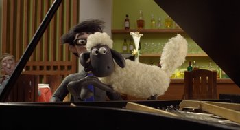 Movie still from “Shaun the Sheep Movie” (2015), directed by Mark Burton – A man and a stuffed sheep are sitting at a piano; Medium shot, High angle