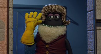 Movie still from “Shaun the Sheep Movie” (2015), directed by Mark Burton – A person wearing a wig and holding up a glove; Close Up shot, High angle