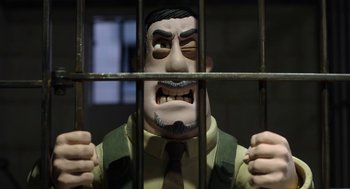 Movie still from “Shaun the Sheep Movie” (2015), directed by Mark Burton – A man in a suit and tie behind bars; Close Up shot, Low angle