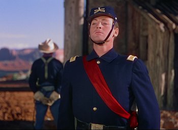 Movie still from “She Wore a Yellow Ribbon” (1949), directed by John Ford – A man in a blue uniform and a red hat; Medium shot, Low angle