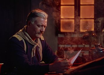 Movie still from “She Wore a Yellow Ribbon” (1949), directed by John Ford – An older man sitting at a table writing on a piece of paper; Medium shot, Over the shoulder angle