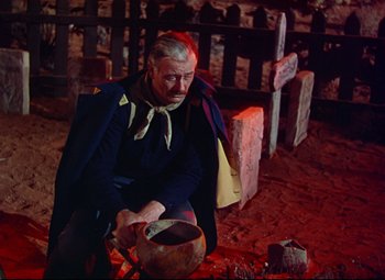 Movie still from “She Wore a Yellow Ribbon” (1949), directed by John Ford – A man sitting on the ground with a pot; Medium shot, High angle