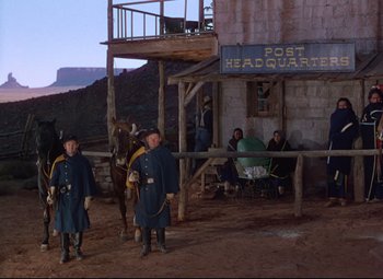 Movie still from “She Wore a Yellow Ribbon” (1949), directed by John Ford – A group of men standing next to each other on a dirt field; Wide shot, Low angle