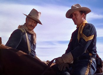 Movie still from “She Wore a Yellow Ribbon” (1949), directed by John Ford – Two men in cowboy outfits on a horse; Medium shot, Low angle