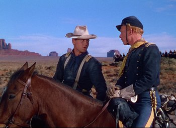Movie still from “She Wore a Yellow Ribbon” (1949), directed by John Ford – Two men on horseback in a desert area; Medium shot, Over the shoulder angle