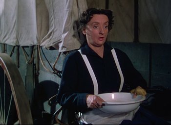 Movie still from “She Wore a Yellow Ribbon” (1949), directed by John Ford – A woman holding a plate with food on it; Medium shot, High angle