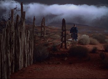 Movie still from “She Wore a Yellow Ribbon” (1949), directed by John Ford – A man standing in front of a wooden fence; Extreme Wide shot, High angle