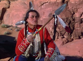 Movie still from “She Wore a Yellow Ribbon” (1949), directed by John Ford – A man in a red shirt holding a spear; Medium shot, Low angle