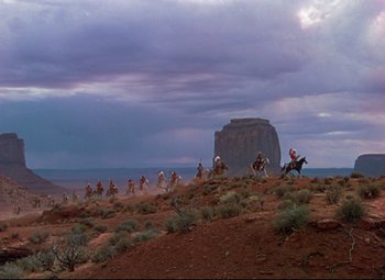 Movie still from “She Wore a Yellow Ribbon” (1949), directed by John Ford – A group of people riding horses on top of a hill; Extreme Wide shot, Low angle