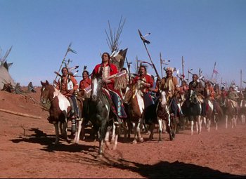 Movie still from “She Wore a Yellow Ribbon” (1949), directed by John Ford – A group of native americans riding on horses; Wide shot, Low angle