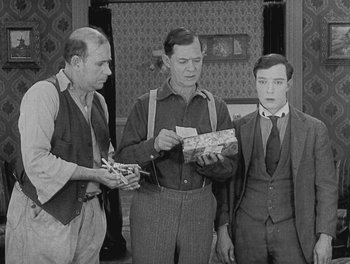 Movie still from “Sherlock Jr.” (1924), directed by Buster Keaton – A group of men standing next to each other; Medium shot, High angle