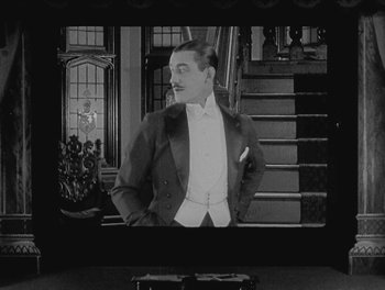 Movie still from “Sherlock Jr.” (1924), directed by Buster Keaton – A black and white photo of a man in a tuxedo; Medium shot, High angle