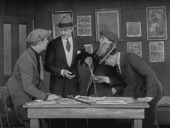 Movie still from “Sherlock Jr.” (1924), directed by Buster Keaton – A group of men standing around a table; Medium shot, High angle