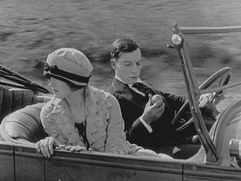 Movie still from “Sherlock Jr.” (1924), directed by Buster Keaton – A man and a woman sitting in the back of a boat; Medium shot, High angle