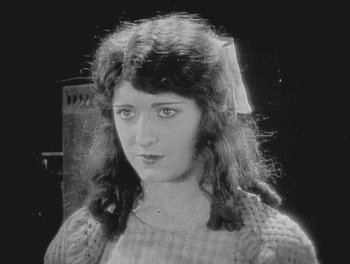 Movie still from “Sherlock Jr.” (1924), directed by Buster Keaton – An old black and white photo of a young woman; Close Up shot, High angle