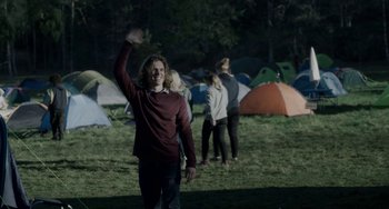 Movie still from “22 July” (2018), directed by Paul Greengrass – A group of people standing in the grass near tents; Extreme Wide shot, Over the shoulder angle
