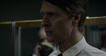Movie still from “22 July” (2018), directed by Paul Greengrass – A person wearing a suit and tie; Close Up shot, Over the shoulder angle