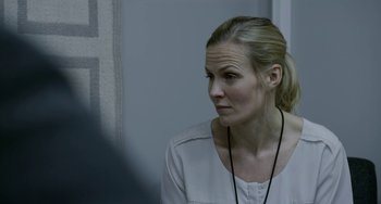 Movie still from “22 July” (2018), directed by Paul Greengrass – A woman in a white shirt is looking at the camera; Close Up shot, Over the shoulder angle