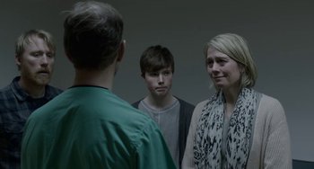 Movie still from “22 July” (2018), directed by Paul Greengrass – A man and two women standing next to each other in front of a mirror; Close Up shot, Over the shoulder angle