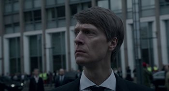 Movie still from “22 July” (2018), directed by Paul Greengrass – A person wearing a suit and tie; Close Up shot, Low angle