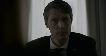 Movie still from “22 July” (2018), directed by Paul Greengrass – A person wearing a suit and tie; Close Up shot, Over the shoulder angle