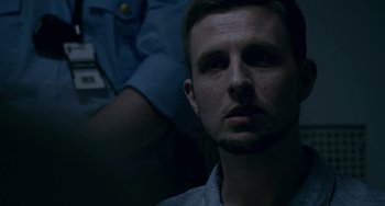 Movie still from “22 July” (2018), directed by Paul Greengrass – A person in a dark room; Close Up shot, Over the shoulder angle