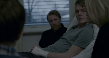 Movie still from “22 July” (2018), directed by Paul Greengrass – A man with a bandaged arm sitting next to another man in a hospital bed; Medium shot, Over the shoulder angle