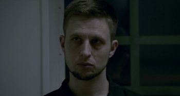 Movie still from “22 July” (2018), directed by Paul Greengrass – A person wearing a black shirt; Close Up shot, Over the shoulder angle