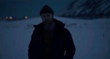Movie still from “22 July” (2018), directed by Paul Greengrass – A man standing in the middle of a snow covered field; Medium shot, Low angle