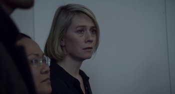Movie still from “22 July” (2018), directed by Paul Greengrass – A woman with short blonde hair is looking to her left; Close Up shot, Over the shoulder angle