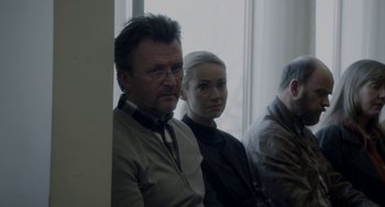 Movie still from “22 July” (2018), directed by Paul Greengrass – A man and a woman sitting next to each other in a room; Medium shot, Over the shoulder angle