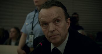 Movie still from “22 July” (2018), directed by Paul Greengrass – A person wearing a suit and tie; Close Up shot, Over the shoulder angle