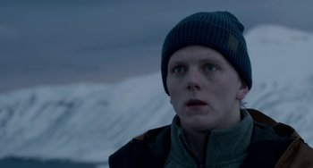 Movie still from “22 July” (2018), directed by Paul Greengrass – A person wearing a hat and a jacket looking to his left; Close Up shot, Low angle
