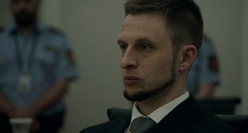 Movie still from “22 July” (2018), directed by Paul Greengrass – A person wearing a suit and tie; Close Up shot, Over the shoulder angle
