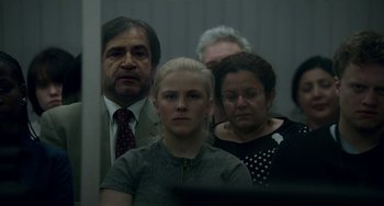 Movie still from “22 July” (2018), directed by Paul Greengrass – A group of people standing next to each other in a room; Medium shot, Over the shoulder angle