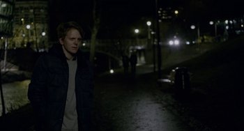 Movie still from “22 July” (2018), directed by Paul Greengrass – A man standing in the dark on a street; Medium shot, Over the shoulder angle