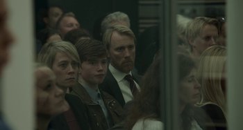 Movie still from “22 July” (2018), directed by Paul Greengrass – A group of people sitting on a train; Close Up shot, Over the shoulder angle